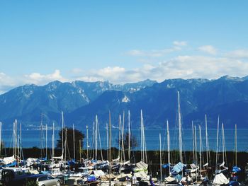 Sailboats moored at harbor against mountains