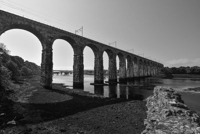 Low angle view of bridge over river against sky