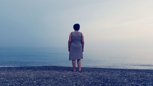 Rear view of woman standing on beach