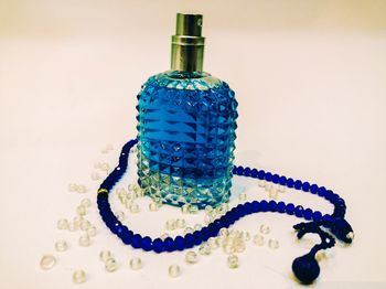 Close-up of blue glass on table against white background