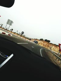 Cars on road against sky seen through car windshield