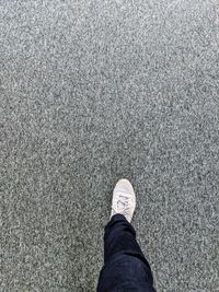 Low section of man standing on road