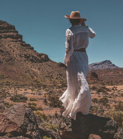 Rear view of woman standing at desert