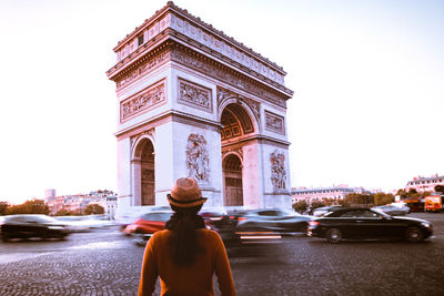 Rear view of woman looking at arc de triomphe on street