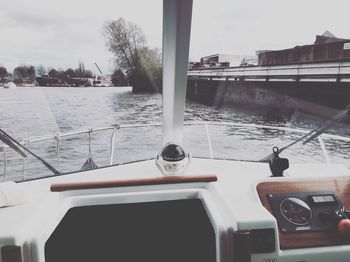 Boat sailing on river in city against sky