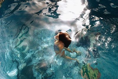 High angle view of girl floating on water