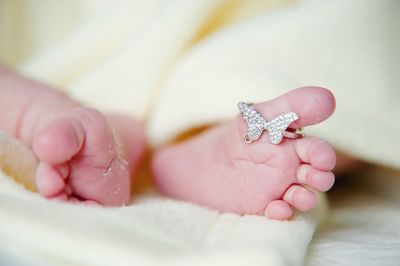 Low section of baby wearing ring on bed