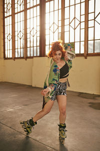 Young alternative redhead girl roller skating in a green kimono