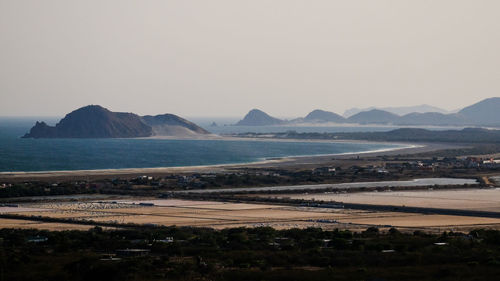 Scenic view of sea and mountains against clear sky