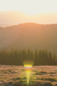 Sun glowing behind mountains silhouette landscape photo