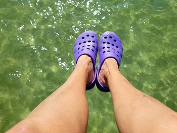 Low section of woman relaxing in swimming pool