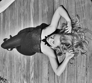 High angle view of young woman lying on boardwalk