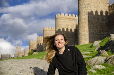 Portrait of young woman standing against sky