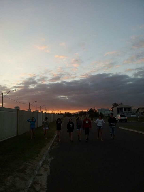 sky, transportation, cloud - sky, men, sunset, mode of transport, lifestyles, large group of people, road, person, land vehicle, leisure activity, street, cloudy, cloud, silhouette, outdoors, dusk, walking