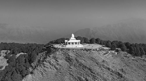 Lighthouse by sea against sky