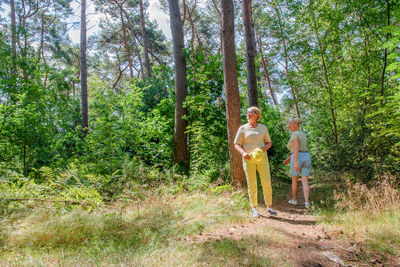 Rear view of woman standing in forest