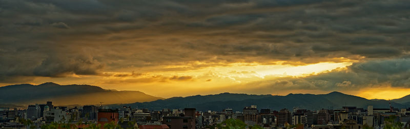 Buildings in city against sky during sunset