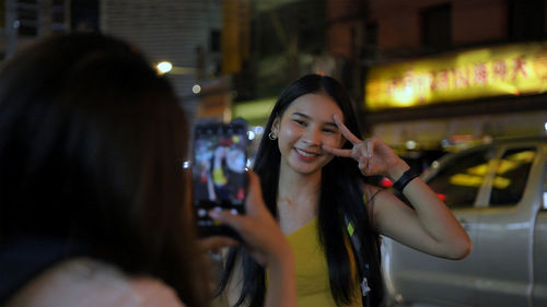 Portrait of beautiful woman in illuminated city