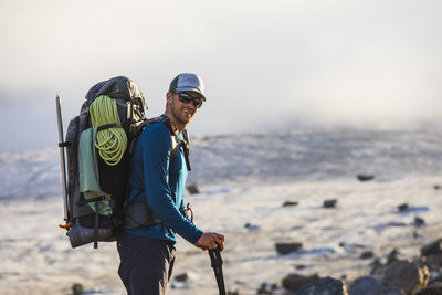 Portrait of climber backpacking across glaciated landscape.