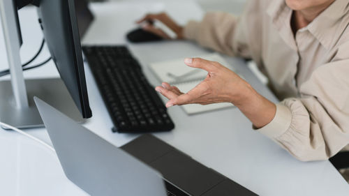 Midsection of woman using laptop on table