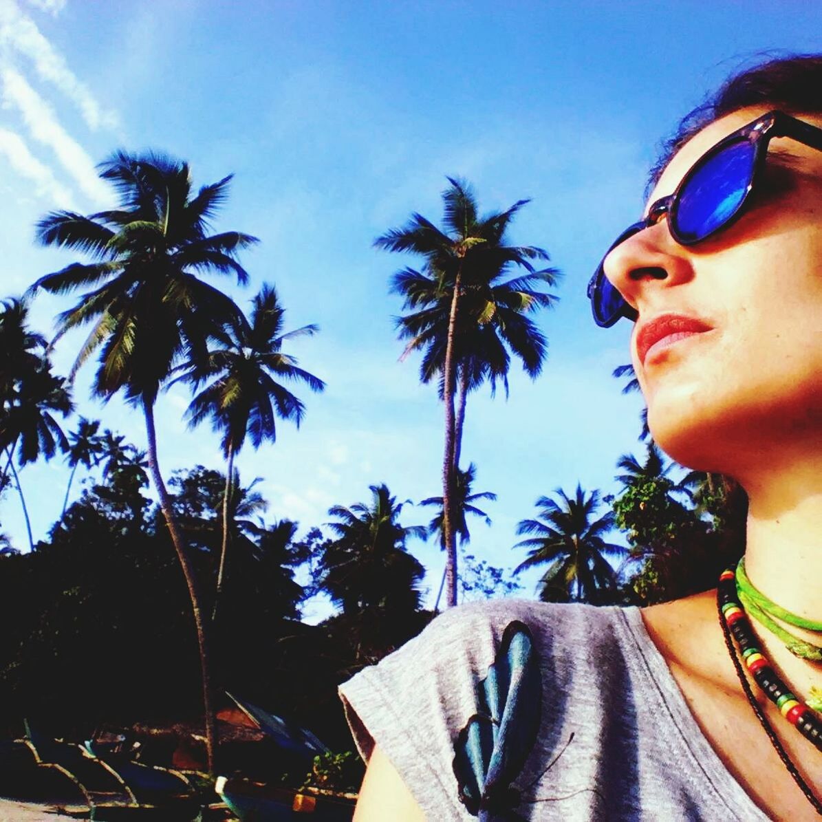 palm tree, sky, looking at camera, young adult, black hair, outdoors, day, tranquility, coconut palm tree