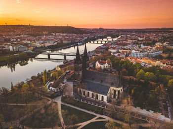 High angle view of river by buildings against sky at sunset