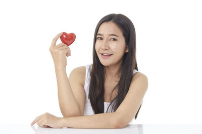 Portrait of a smiling young woman against white background