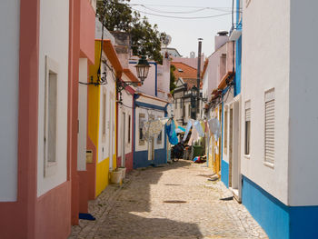 Rear view of woman walking on street amidst buildings