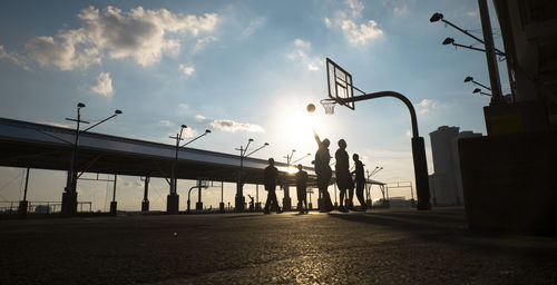 People walking on road at sunset