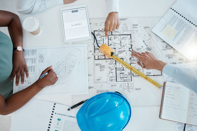 Cropped image of business people working on blueprint