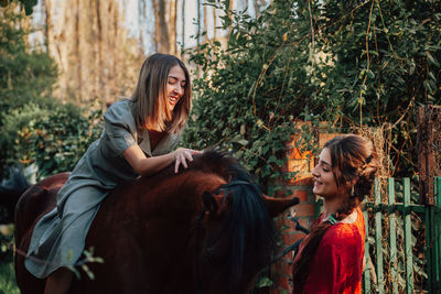 Woman standing with horse an friend