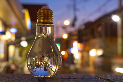 Close-up of illuminated light bulb on table