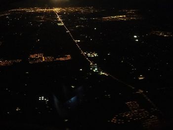 High angle view of illuminated cityscape against sky at night