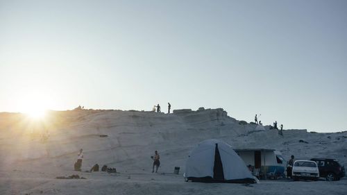 Group of people on land against clear sky