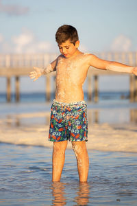 Little kid covered in sand on the beach