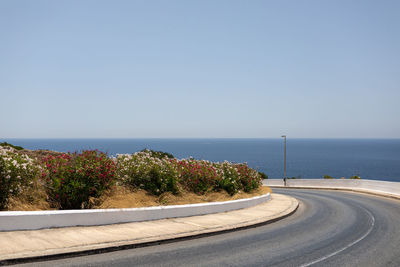 Road by sea against clear sky