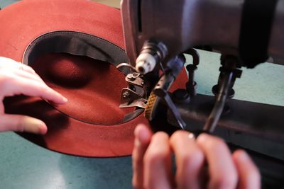 Cropped hands of person working on sewing machine