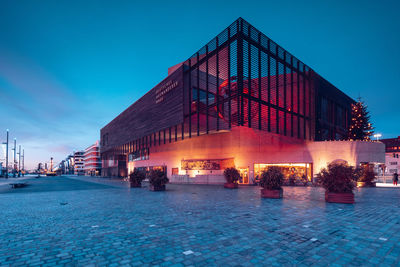 Illuminated building against sky at dusk