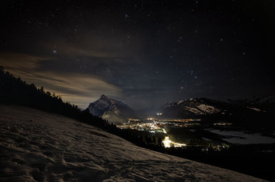 Scenic view of illuminated mountains against sky at night