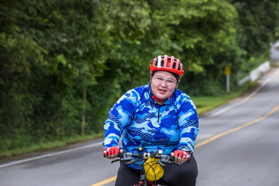 Portrait of man riding bicycle on road