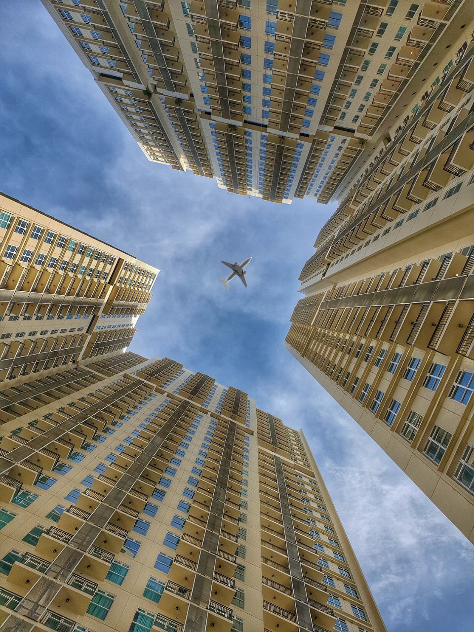 DIRECTLY BELOW SHOT OF MODERN BUILDINGS AGAINST SKY