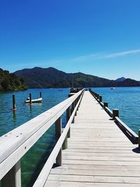 Pier over lake against blue sky