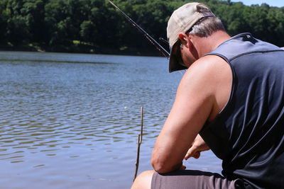 Side view of man fishing at lake