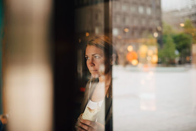 Portrait of woman looking away in city