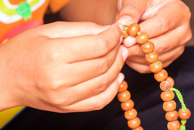 Close-up of hands holding prayer beads
