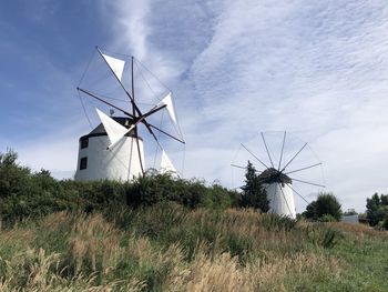 Traditional windmill on field against sky