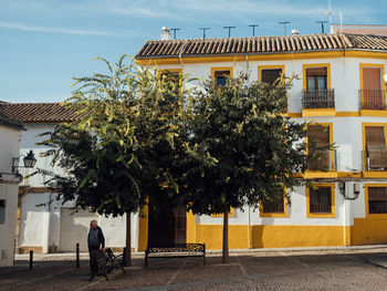 Man walking on street by building in city
