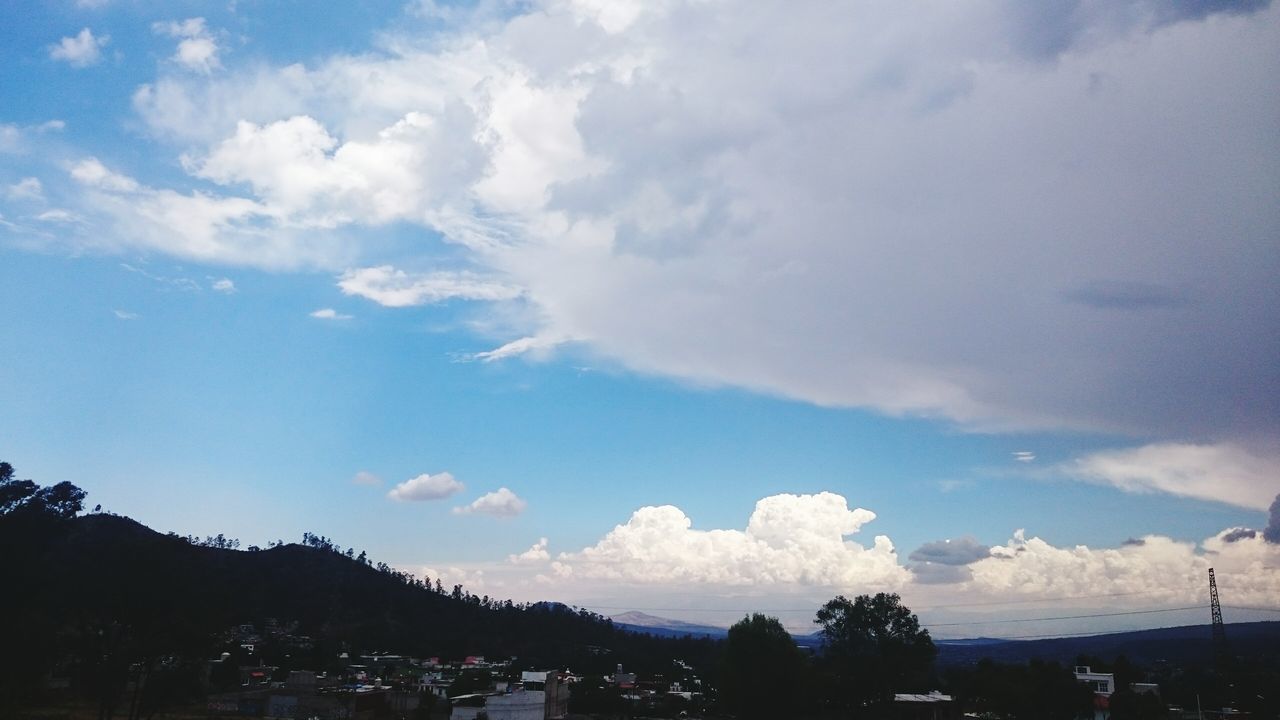 sky, cloud - sky, tree, low angle view, cloud, mountain, cloudy, silhouette, beauty in nature, nature, scenics, tranquility, tranquil scene, blue, outdoors, day, built structure, building exterior, no people, transportation