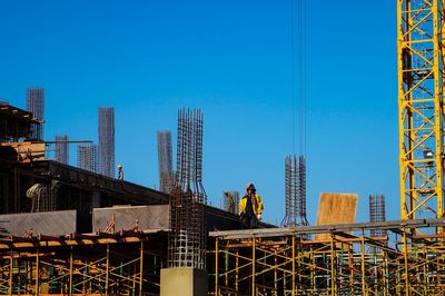 View of construction site against clear blue sky