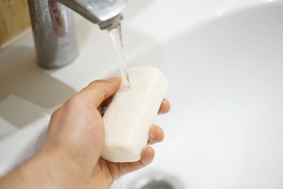 Close-up of hand holding white pouring